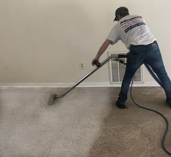 Advanced-cleaning-restoration-employee-carpet-cleaning Employee of Advanced Cleaning & Restoration cleaning a very soiled carpet
