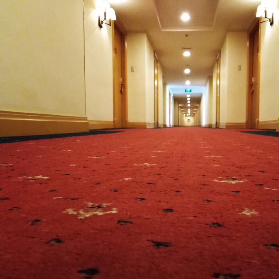 Hotel carpet after professional carpet cleaning job hallway stretching into distance